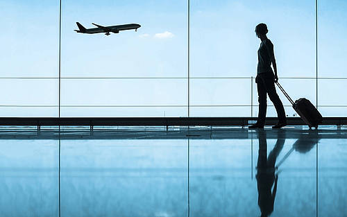 Frau mit Koffer am Flughafen