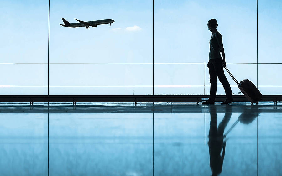 Frau mit Koffer am Flughafen