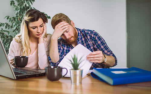 Verzweifeltes Paar sitzt am Tisch