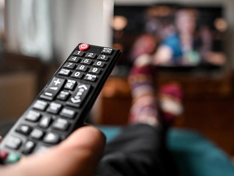 Ein junger Mann sitzt mit einer Fernbedienung vor dem Fernseher. Foto: Britta Pedersen/dpa-Zentralbild/dpa