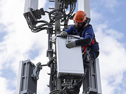 Ein Techniker installiert eine Antenne für das 5G-Funknetz auf einem Hausdach. Foto: Peter Klaunzer/KEYSTONE