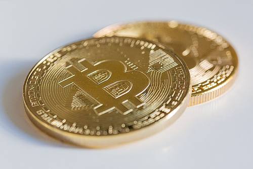 Zwei Bitcoin-Münzen liegen auf einem Tisch.