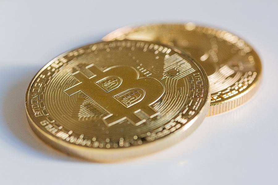 Zwei Bitcoin-Münzen liegen auf einem Tisch.