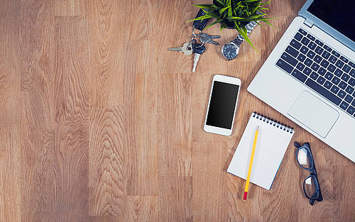 Schreibtisch mit Laptop und Smartphone