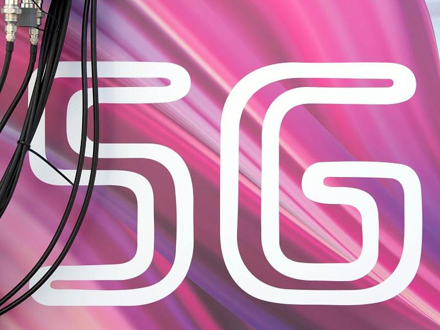 Antennenkabel verlaufen vor dem Schriftzug «5G». Foto: Sebastian Kahnert/dpa-Zentralbild/dpa