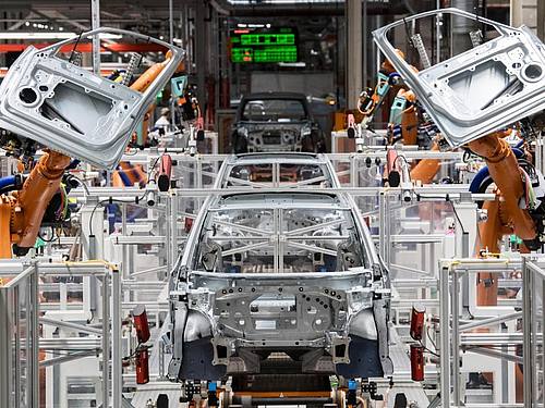Maschine statt Mensch: Roboter montieren Türen eines Autos. Foto: Hendrik Schmidt/dpa