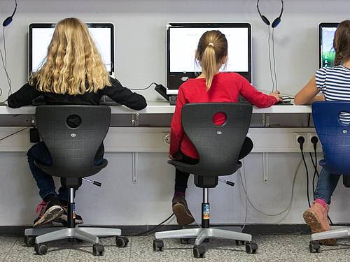 Schülerinnen arbeiten in einem Klassenraum einer Grundschule an Computern. Foto: Friso Gentsch/dpa
