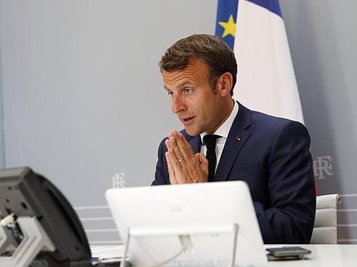 Emmanuel Macron nimmt aus dem Elysee-Palast heraus gestenreich an der WHO-Videokonferenz teil. Foto: Christophe Ena/AP/dpa
