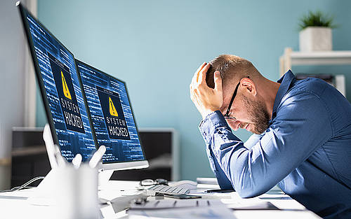 Mann vor Monitoren