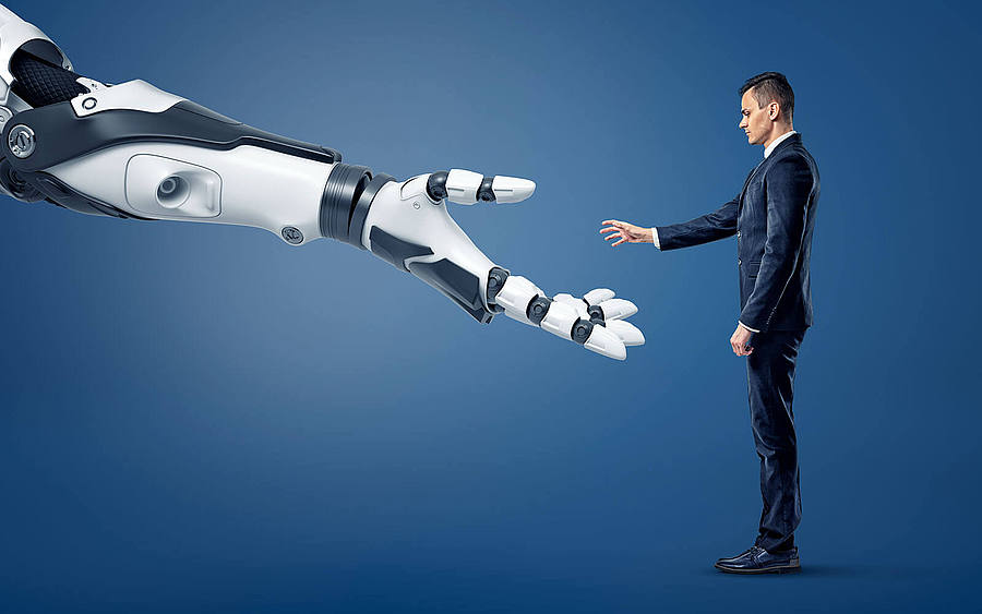 Geschäftsmann reicht einem Roboter die Hand
