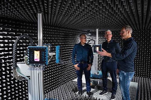 Apple-Chef Tim Cook (M) zusammen mit zwei Mitarbeitern im Entwicklungszentrum des Konzerns in München.