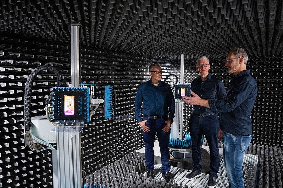 Apple-Chef Tim Cook (M) zusammen mit zwei Mitarbeitern im Entwicklungszentrum des Konzerns in München.