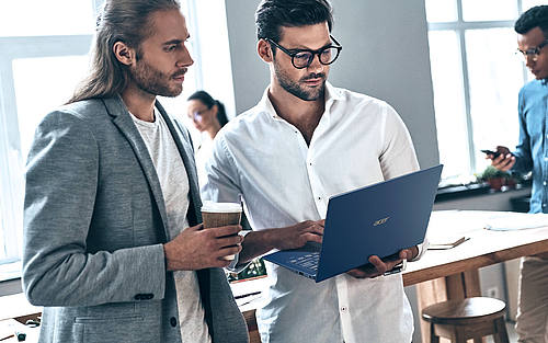 Eine Gruppe junger Männer steht in einem modernen Büro