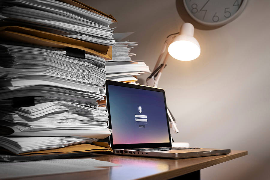 Dokumentenstapel mit Laptop