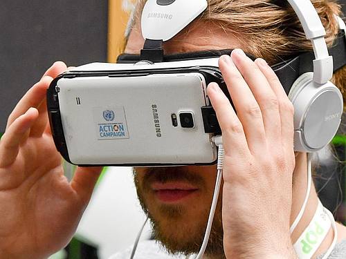 Ein Besucher der Internetkonferenz re:publica schaut im Mai in eine an ein Smartphone montierte VR-Brille. Foto: Jens Kalaene