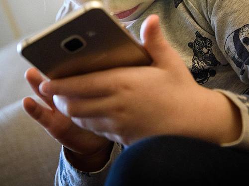 Kleinkind am Smartphone: Heimlich einfach weitergespielt. Foto: Hans-Jürgen Wiedl/dpa/Symbolbild