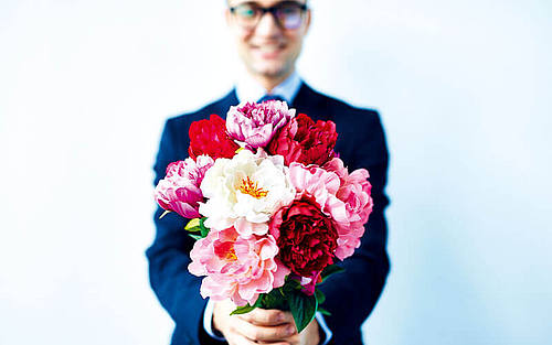 Ein Mann hält einen Blumenstrauss