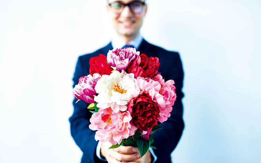 Ein Mann hält einen Blumenstrauss