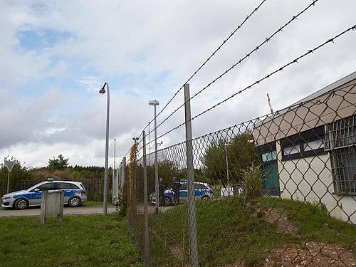 Polizisten sichern das Gelände, auf dem ein Rechenzentrum für illegale Geschäfte ausgehoben wurde. Foto: Thomas Frey/dpa/Archivbild