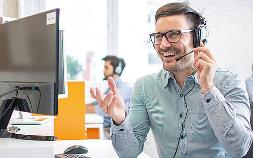 Mann im Kundenservice-Center mit Headset