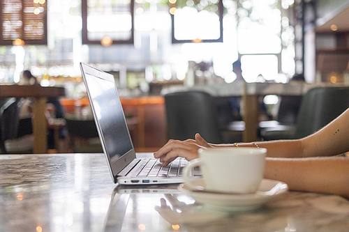Notebook und Kaffeetase im Cafe