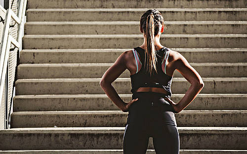 Eine Joggerin steht vor einer steilen Treppe