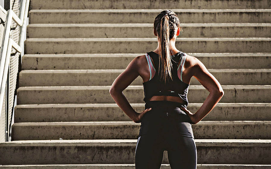 Eine Joggerin steht vor einer steilen Treppe