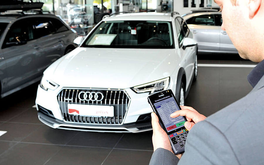Autoverkäufer gibt Barcode in Handheld ein