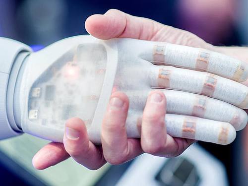 Handschlag zwischen Roboter und Mensch
