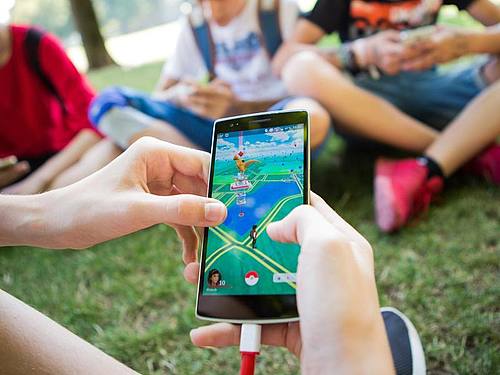 Jugendliche spielen in einem Park das Smartphone-Spiel «Pokemon Go». Foto: Silas Stein/dpa