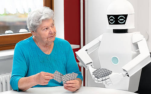 Ältere Dame spielt Karten mit Roboter