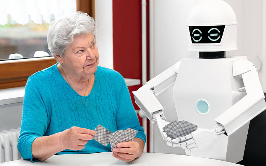 Ältere Dame spielt Karten mit Roboter