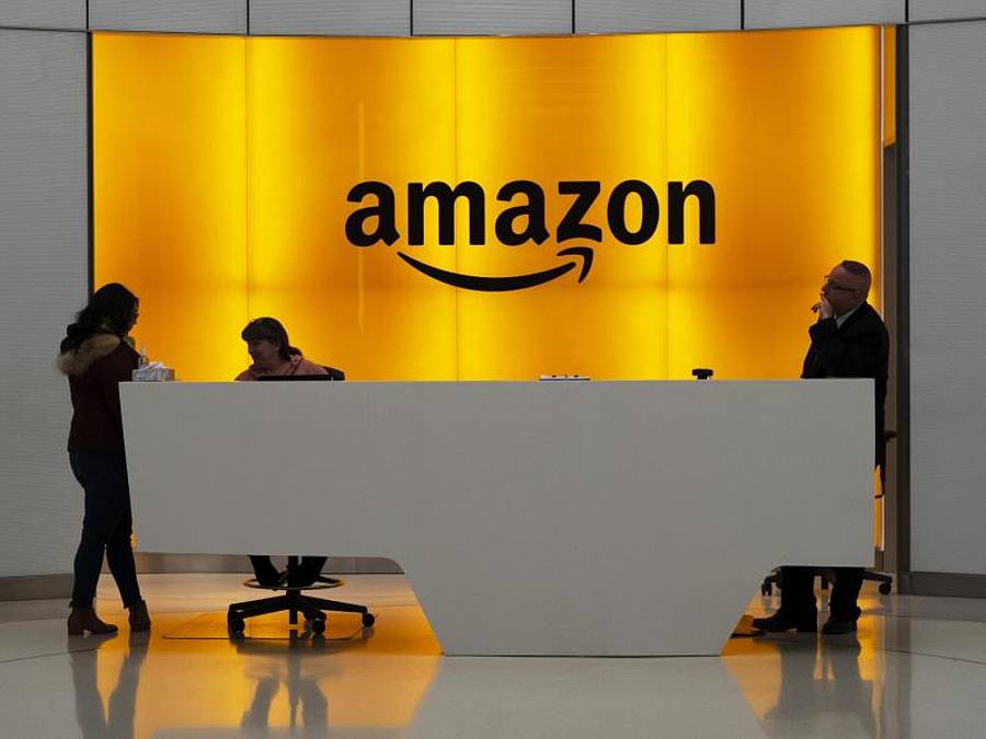 Menschen stehen in der Lobby der New Yorker Amazonas-Büros. Foto: Mark Lennihan/AP/dpa