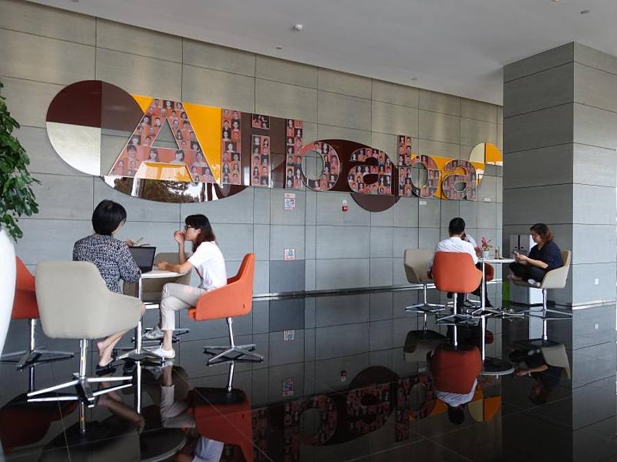 Mitarbeiter sitzen in einem Foyer der Firmenzentrale von Alibaba in Hangzhou. Foto: Andre Klohn/dpa