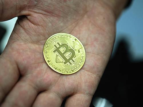 Eine nachgemachte Münze mit dem Logo der Digitalwährung Bitcoin. Foto: Nicolas Armer/dpa