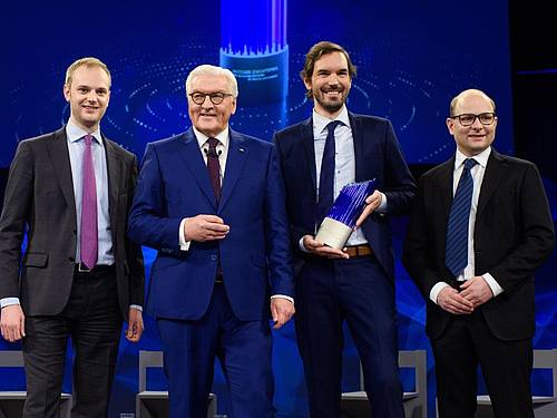 Frank-Walter Steinmeier (2.v.l.), Bundespräsident, steht gemeinsam mit den Preisträgern des deutschen Zukunftspreises, Alexander Rinke (l-r), Martin Klenk und Bastian Nominacher, nach der Verleihung auf der Bühne. Foto: Gregor Fischer/dpa