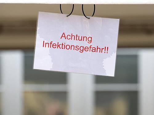 Ein Schild mit der Aufschrift „Achtung Infektionsgefahr!“  an einem Johanniter-Zelt in Brandenburg.
