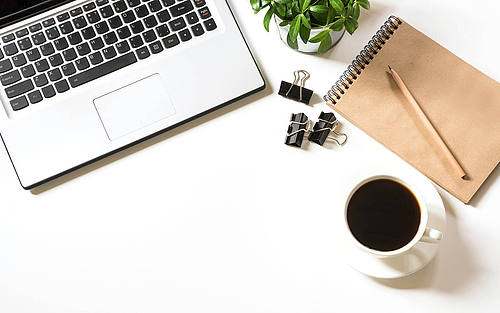 Ein Schreibtisch mit einem Laptop und einer Tasse Kaffee