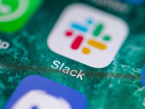 Der Bildschirm eines iPhones zeigt die Messenger-App Slack. Foto: Fabian Sommer/dpa
