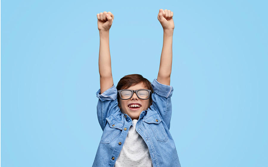 Junge mit Brille jubelt