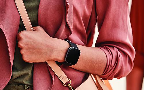 Die Fitbit Versa 2TM am Handgelenk einer jungen Frau