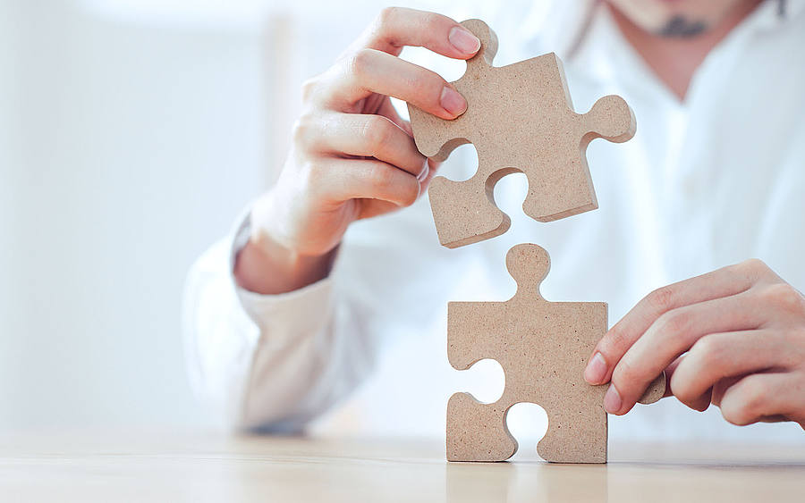 Zwei Puzzleteile werden zusammengesteckt