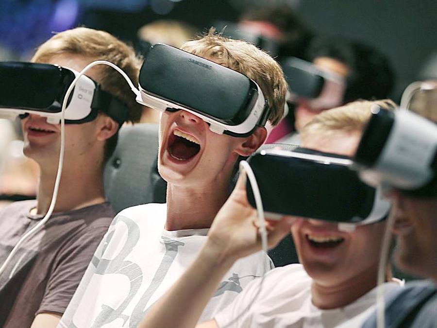 Besucher der Gamescom tauchen mittels VR-Brillen in ein Computerspiel ein. Foto: Oliver Berg/Archiv