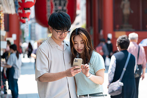 Junges chinesisches Paar schaut auf ein Smartphone