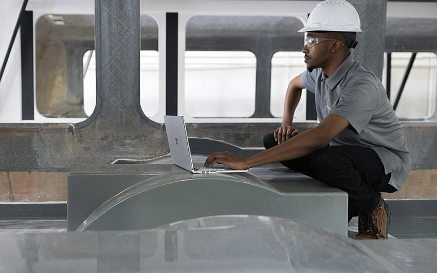 Mann mit Laptop auf einer Baustelle