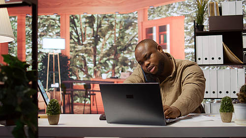 Person telefoniert und arbeitet am Notebook