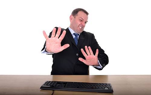 Erschreckter Mann vor Computer