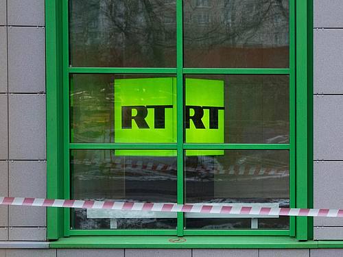 Das Logo des staatlichen russischen TV-Senders RT ist im Fenster des Firmenbüros zu sehen. Foto: Pavel Golovkin/AP/dpa