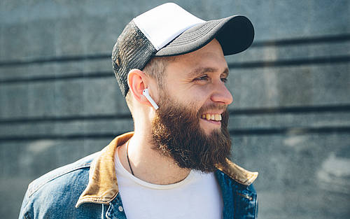 Mann mit drahtlosen In-Ear-Kopfhörern
