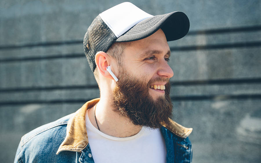 Mann mit drahtlosen In-Ear-Kopfhörern